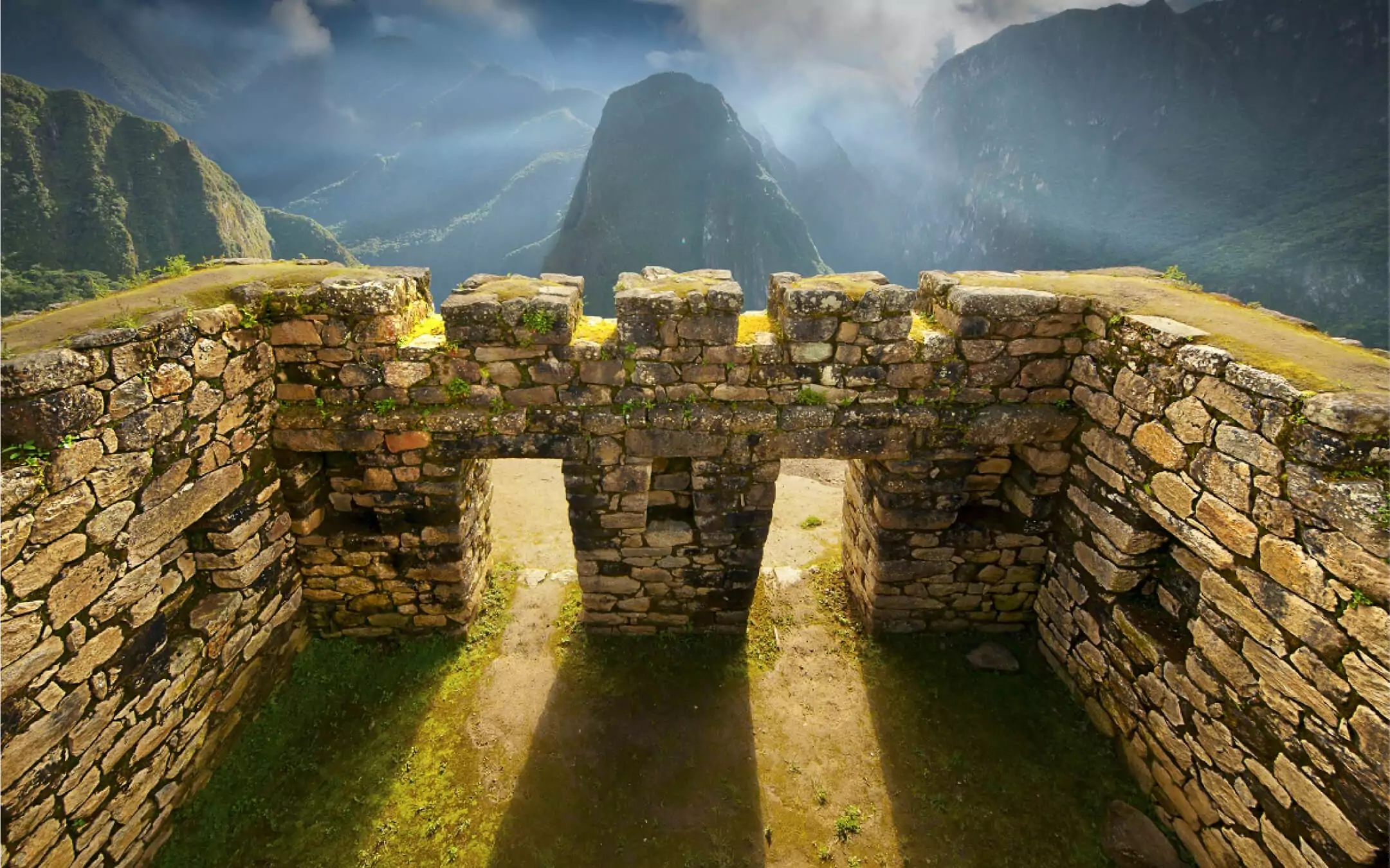 Stone structure with triple windows at Machu Picchu under sunlight